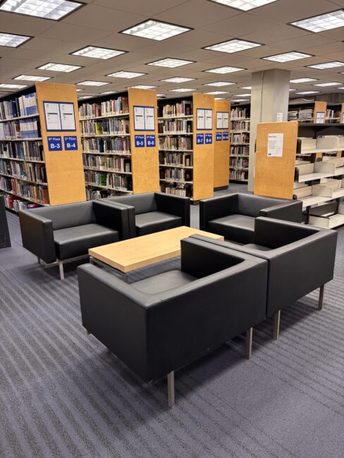 Five black leather armchairs with a shared table